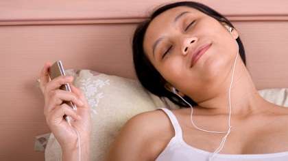 A woman relaxing to music.